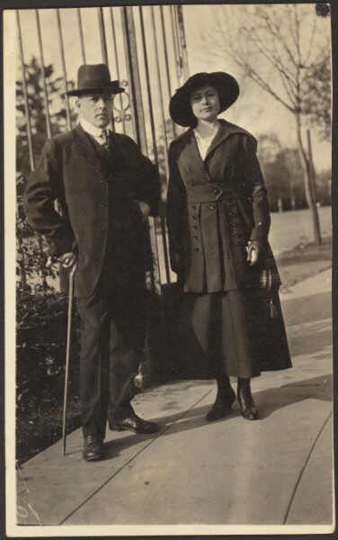 Louis Fleckenstein, [Man and Woman Before Metal Fence]