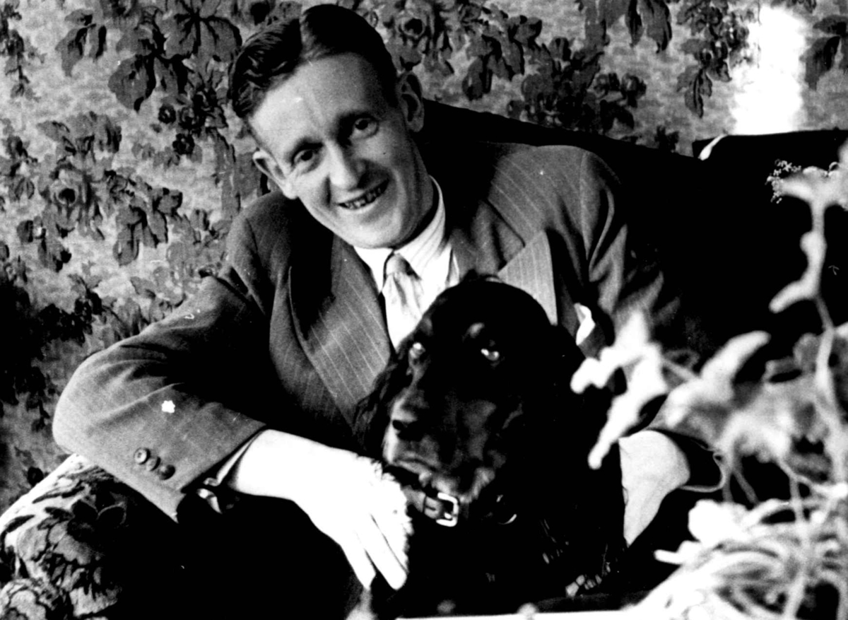 Anna Grostøl, Mann med hund sitter i stol, Fiane. Borre 1938.