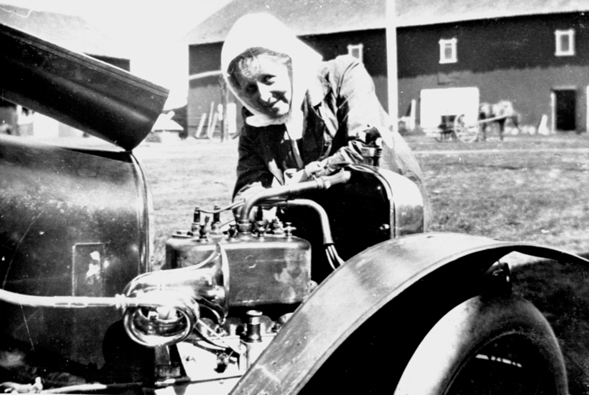 Anno Domkirkeodden, Thora Løken ved en Adler bil modell 1914, D-53. Hun var første kvinne som tok førerkort i Hedmark i 1914. Her på gardstunet på Granerud gård, Brumunddal.