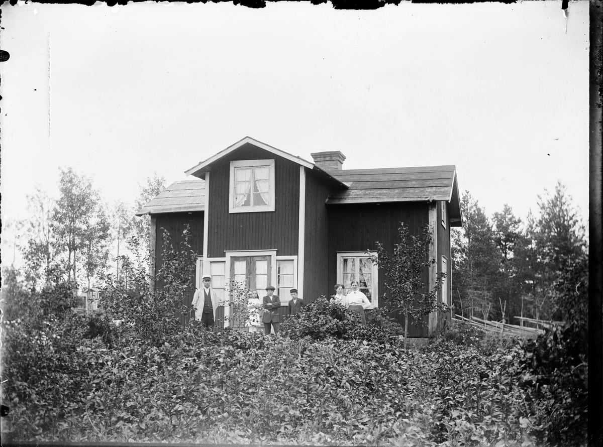 Skötsner-Edhlund, Man, kvinnor och barn framför bostadshus, Östhammar, Uppland