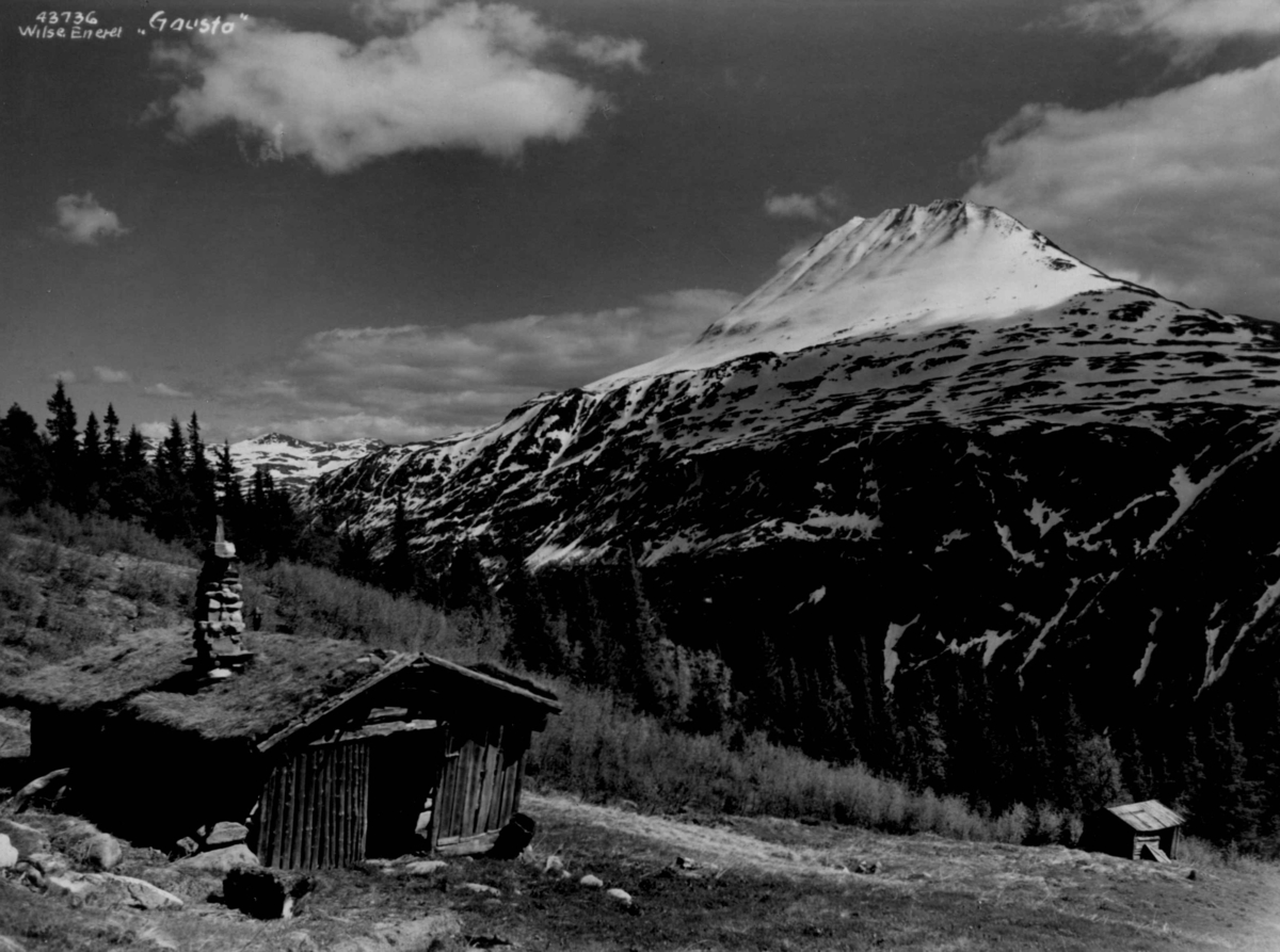 Anders Beer Wilse, Gaustatoppen med falleferdig bygning i forgrunnen. Snødekt fjell.