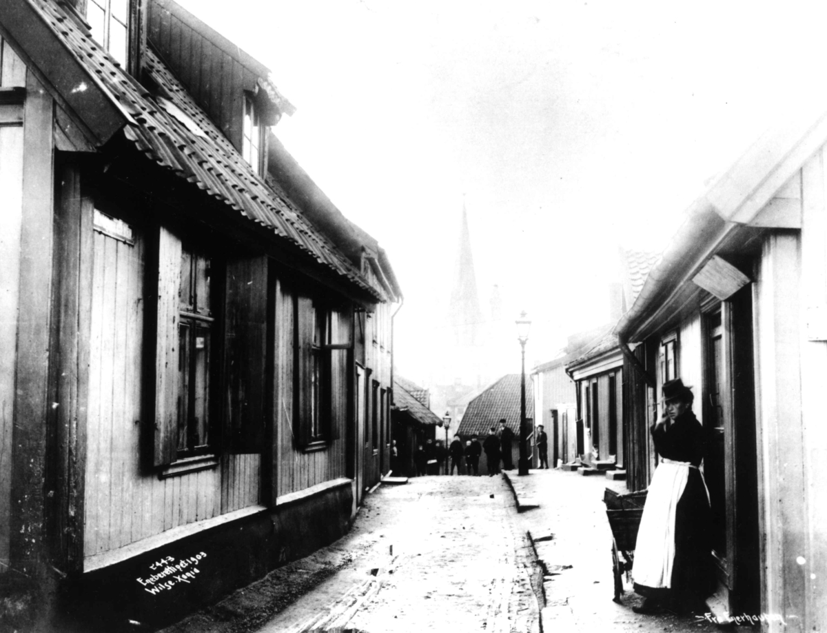 Anders Beer Wilse, Enerhaugen, Oslo 1903. Smal bygate med trehus og mennesker.