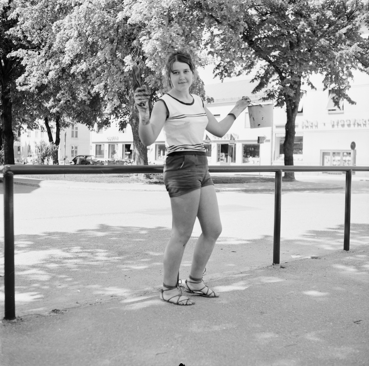 Tierp Arbetarbladet, Anneli Morberg målar staket under sitt feriearbete hos Tierps köpings parkavdelning, Tierp, Uppland juni 1968
