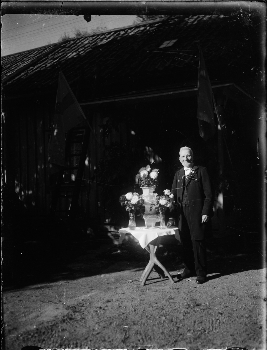 Skötsner-Edhlund, Man stående vid bord med blommor, Uppland
