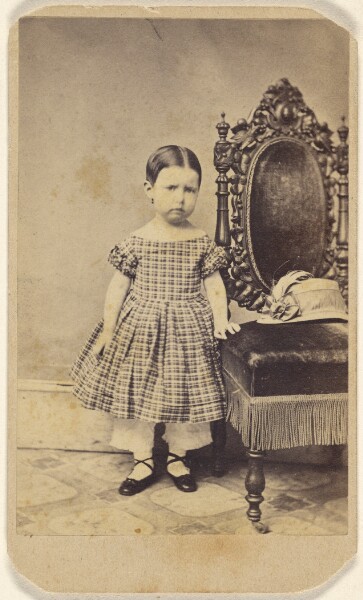 Unknown, [Unidentified little girl standing near an ornate chair]