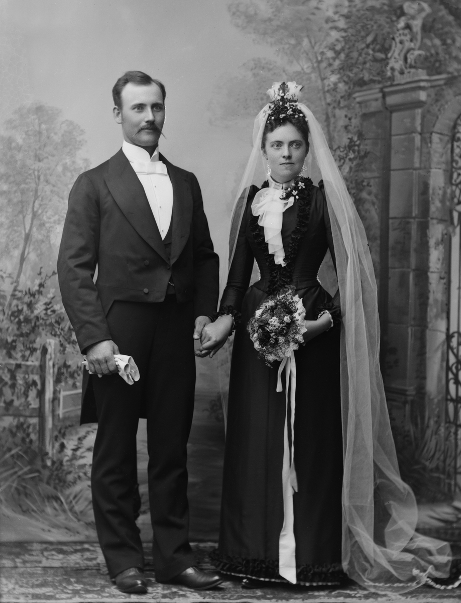 Maria Tesch, Grosshandlare Norrdell med fru. Porträtt. Par. Bröllop. Vigsel. Studiofotografi. Foto: Maria Tesch. Fotograferad i Maria Teschs ateljé som fanns i Linköping åren 1873 - 1936. Digitaliserad efter original glasnegativ som förvaras på Stiftsbiblioteket /Linköpings stadsbibliotek.