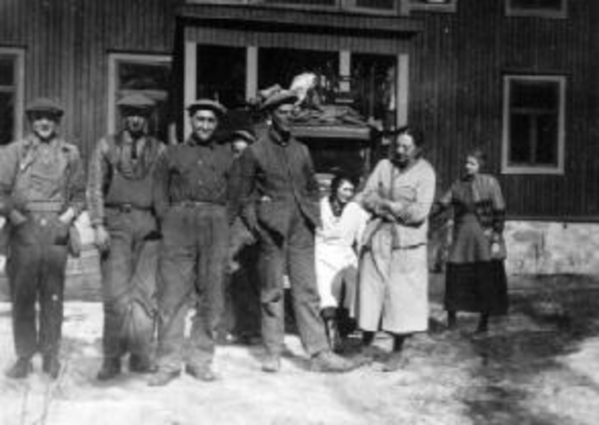 Anno Domkirkeodden, Stor gruppe voksne i arbeidsklær. Flyttelass på bil, Gønner Sveinhaug f.1875 med hendene i kors.