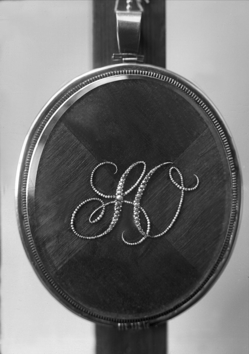 Gustav Borgen, Henriksens monogram på baksiden av medaljong.