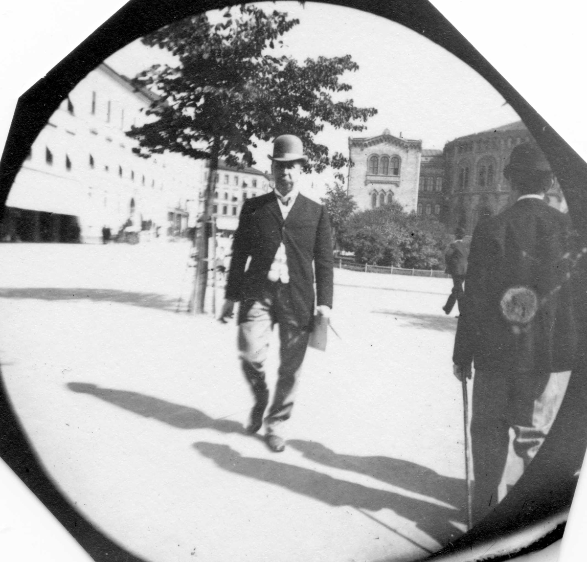 Fredrik Carl Mülertz Størmer, Apoteker G. L. Størmer, fotografens far, spaserer langs Karl Johans gate, Oslo, med Stortinget i bakgrunnen.