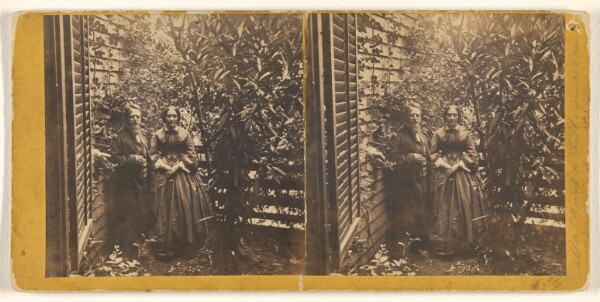 Carleton Watkins, [Older couple posed by side of a house with much foliage]