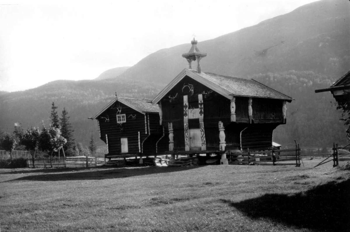 Hermann Christian Neupert, Kjønntveit, Nore, Nore og Uvdal. 1930. Stabbur og loft. Gårdstun. Skog og fjell i bakgrunnen.