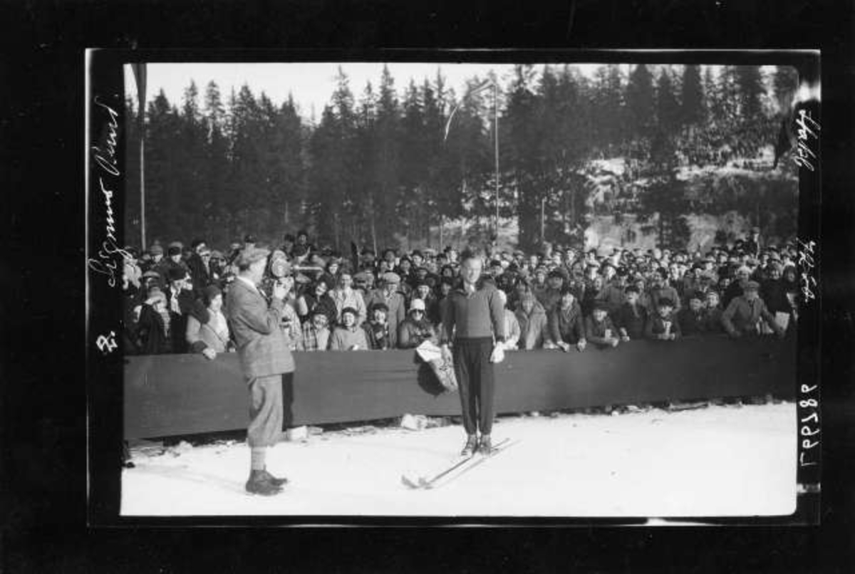 Hermann Christian Neupert, Holmenkollen. Skihopper Sigmund Ruud filmes på sletta. Publikum i bakgrunnen.