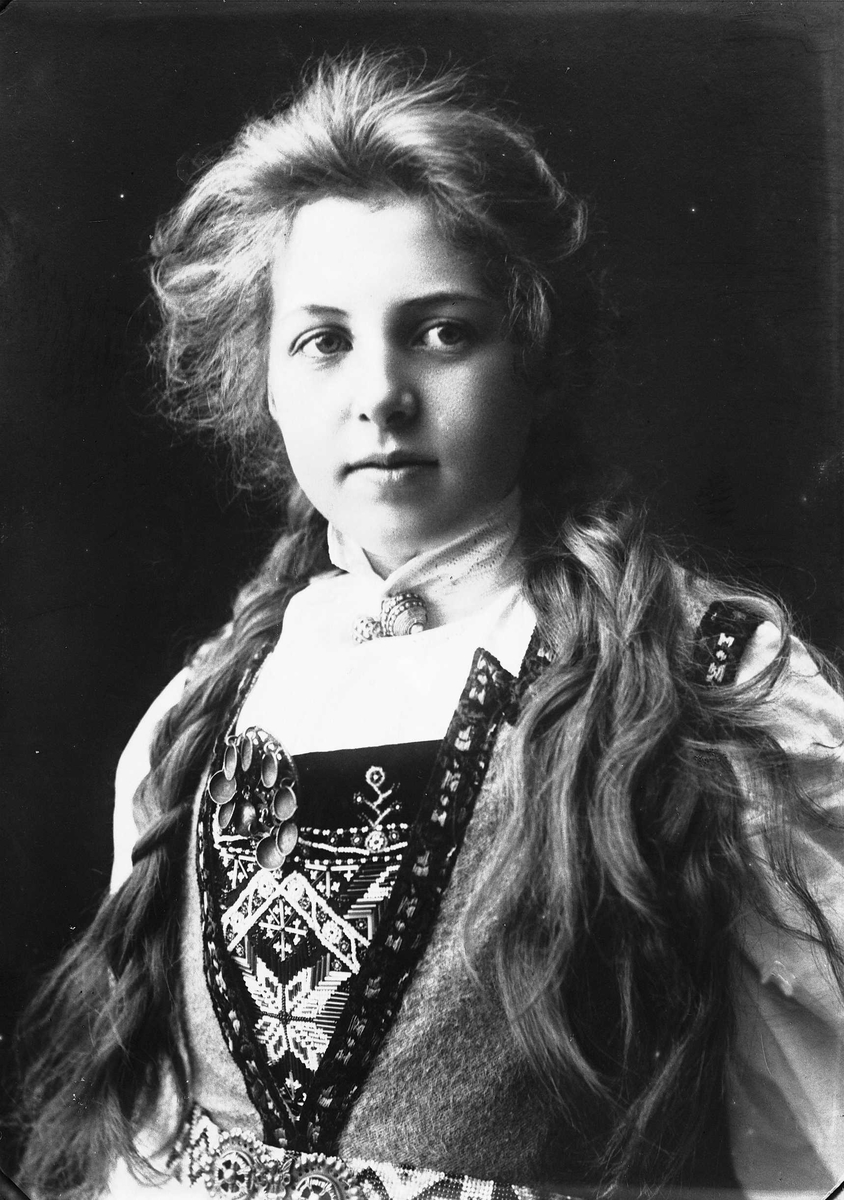 Solveig Lund, Studioportrett av kvinne i drakt med fletter.