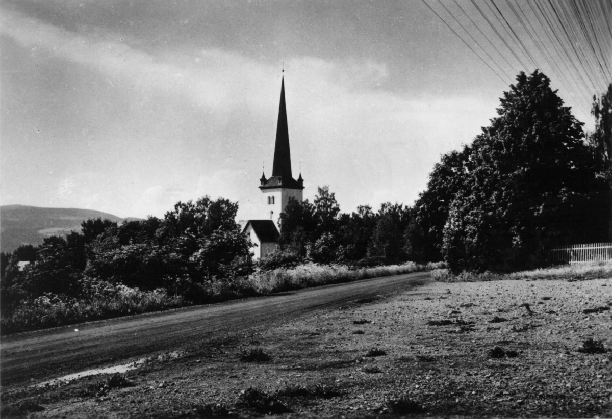 Hermann Christian Neupert, Ringsaker kirke. Landskap med skog. Vei i forgrunnen. Skogkledd ås i bakgrunnen.