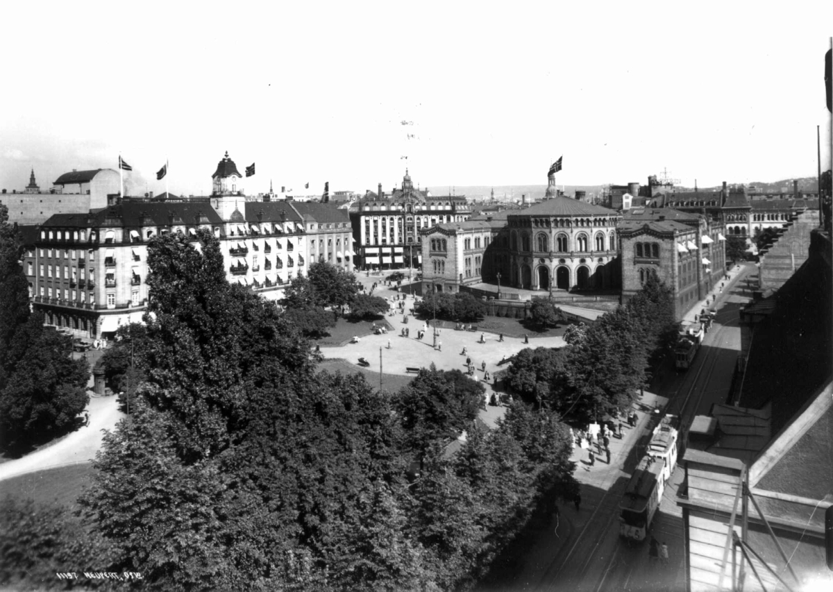 Hermann Christian Neupert, Utsikt over Grand Hotel og Stortinget, Oslo 1934. Oversiktsbilde. Gater med trikker og fotgjengere.