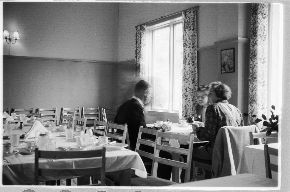 Håkon Prestkværn, Interiør, restaurant. Ukjente personer spiser og drikker rundt et bord.
