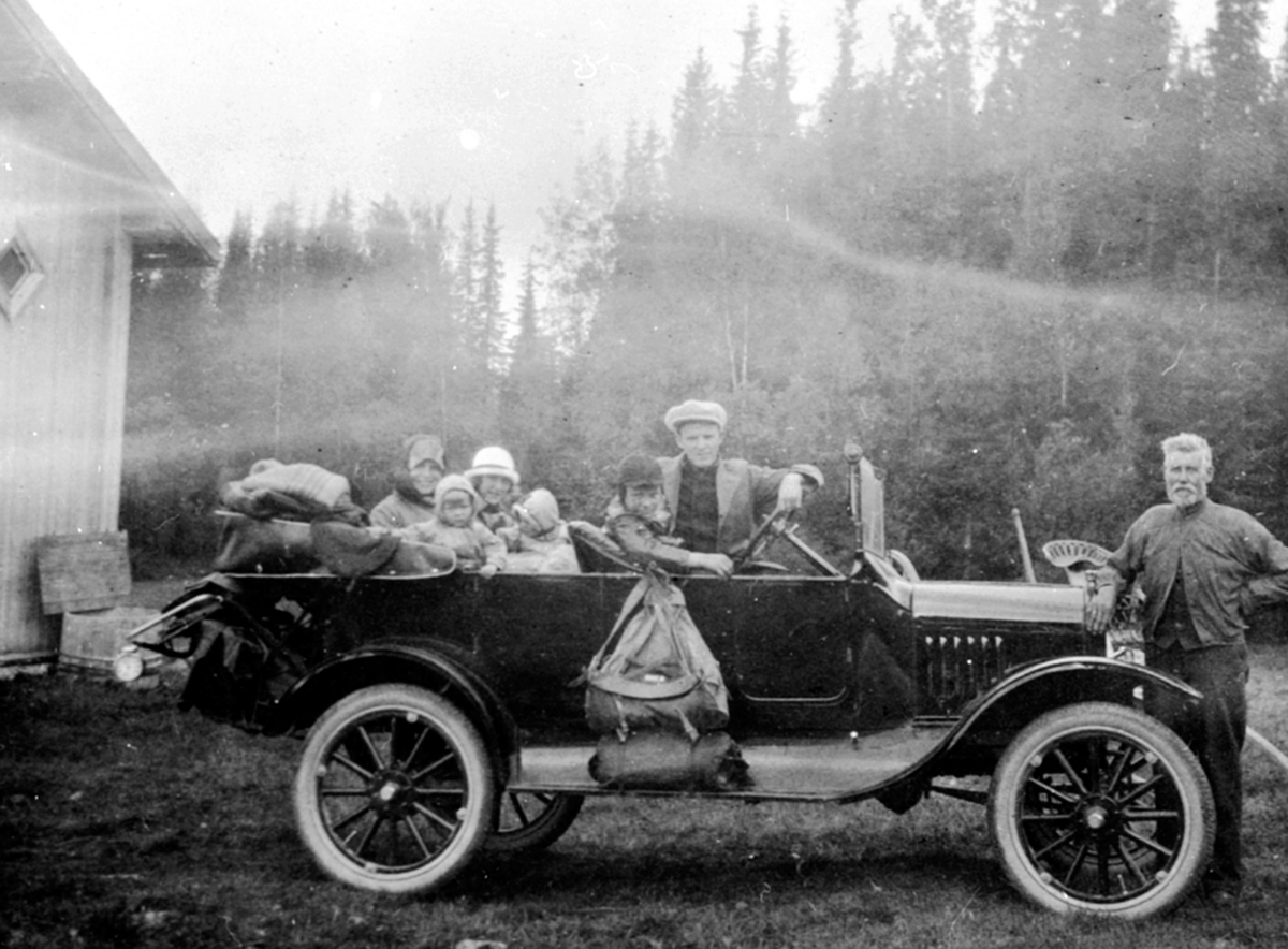 Anno Domkirkeodden, Familien Løken fra Granerud gård, Brumunddal på biltur i Ringsakerfjellet i en Ford T 1919-22 modell, D-111. Foran bilen er Ole Harkerud. Sjåfør er doktor Karl Løken, barna, Alfhild Løken i baksetet:
