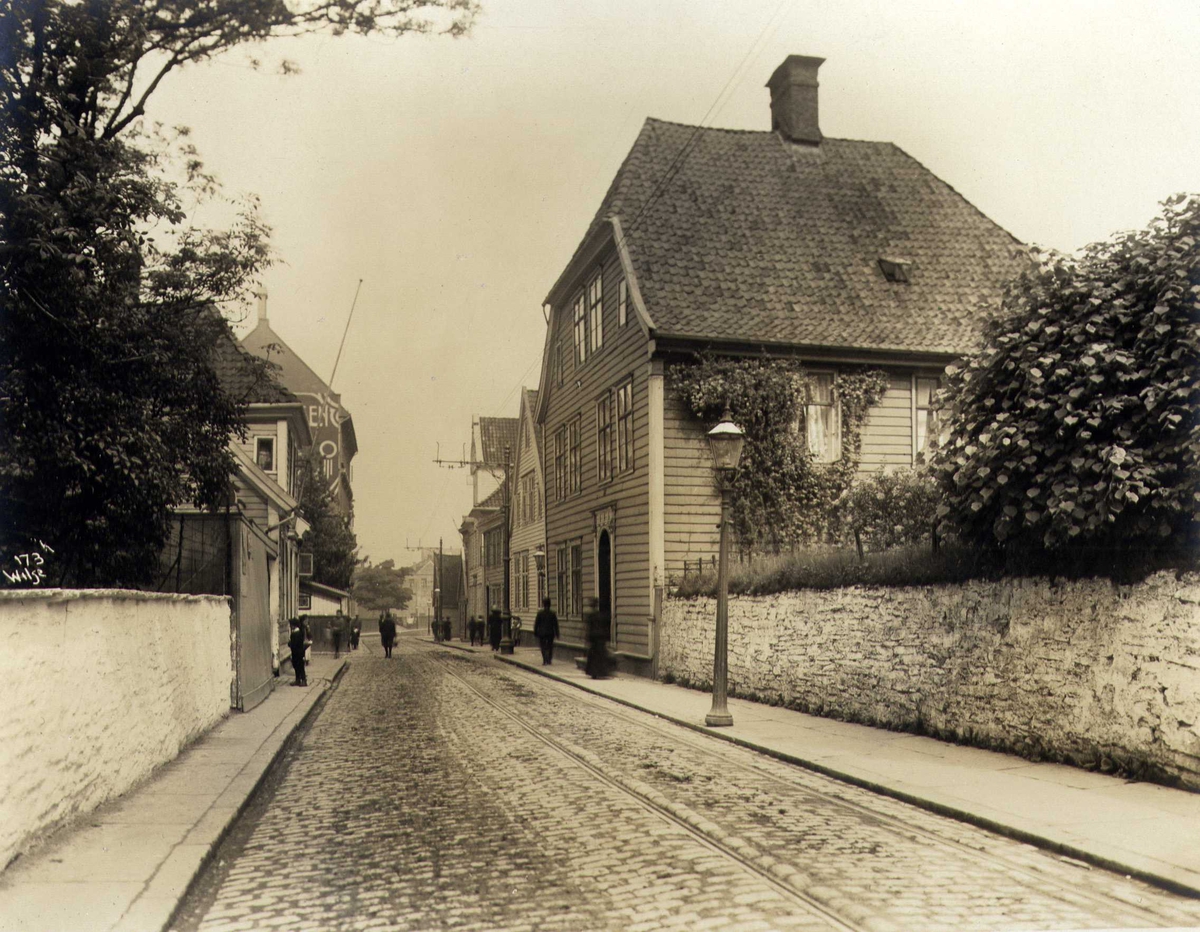 Anders Beer Wilse, Gateparti med trehusbebyggelse, Kong Oscars gate, Bergen, Hordaland. Fotografert 1912.