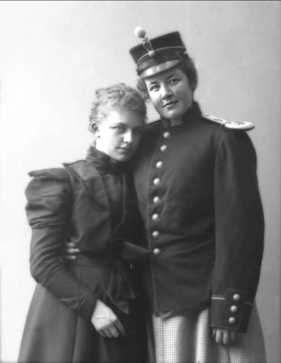 Gustav Borgen, Gruppeportrett, to unge kvinner. Den ene utkledd i militær uniformsjakke og lue.