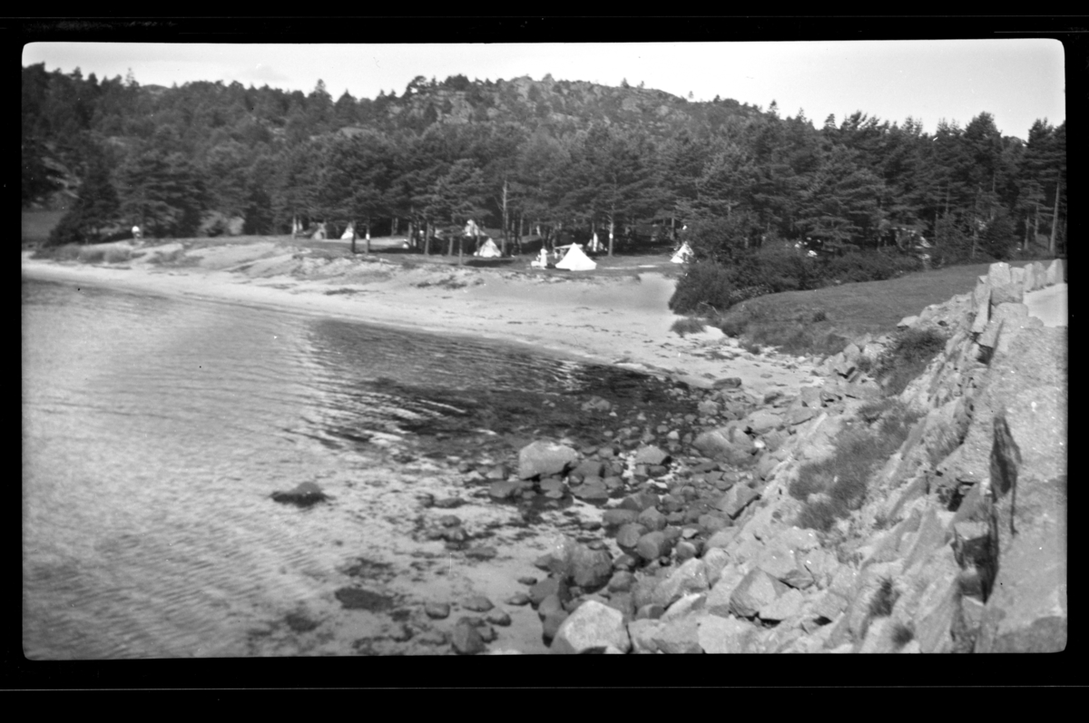 Rolf Sr. Sundt, Strand ved Fevik, med teltplass i skogen bak. Fotografert juli 1932.