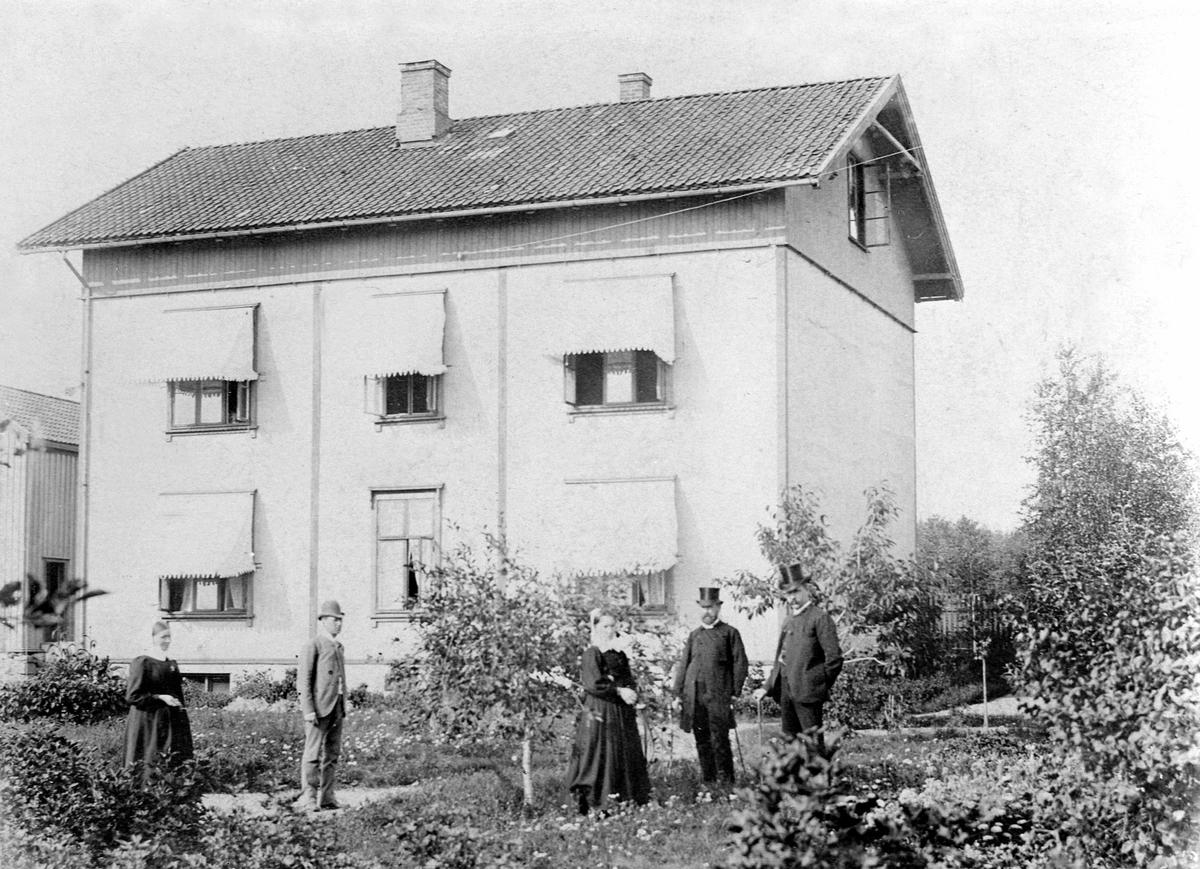 Anno Domkirkeodden, Eksteriør fra Hamar Sykehus 1895. Gruppe fra ledelse og personal i hagen. Fra venstre er diakonisse Tilla Iversen, sykehuslege Carl Robert Henie, diakonisse Betzy Beichman, tredjeprest Hans Emil Erichsen, stadslege Albert Lutzov.
