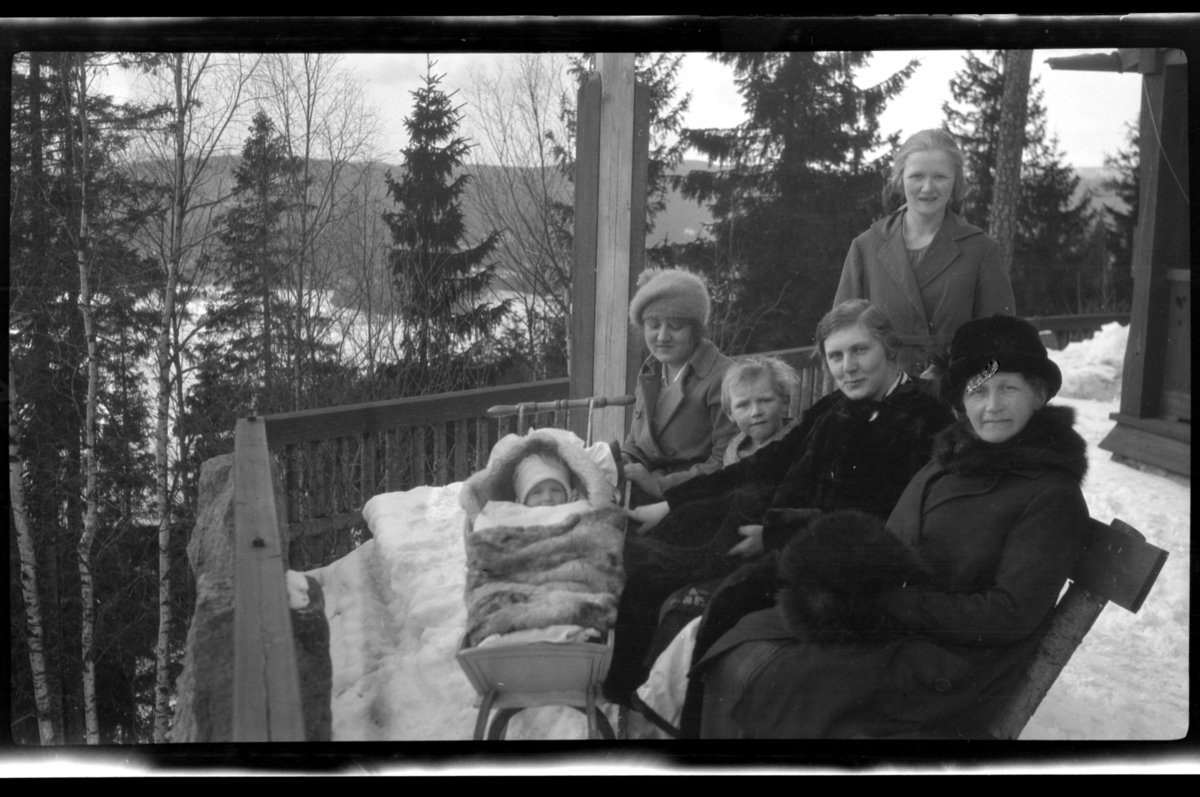 Rolf Sr. Sundt, Rolf Sundt Jr. i vuggen, en barnepike, Julius Sundt, Hilda Sundt, Julie Cecilie (Essemor) Sundt og Rebekka Sundt i snøen utenfor Villa Knyggen i Voksenlia, Oslo. Fotografert 1922.