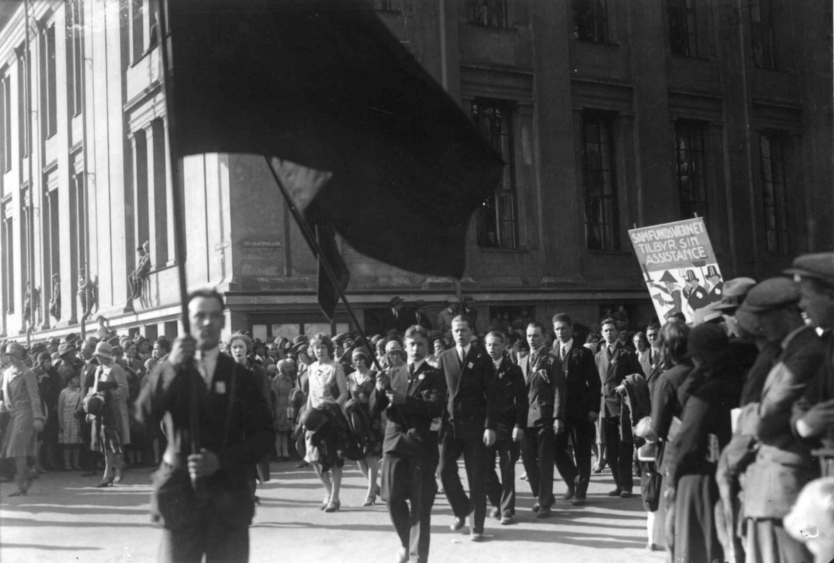 Hermann Christian Neupert, 1. mai-tog, Karl Johans gate. 1930. Universitetet i bakgrunnen. Menn og kvinner. Faner. Tilskuere.