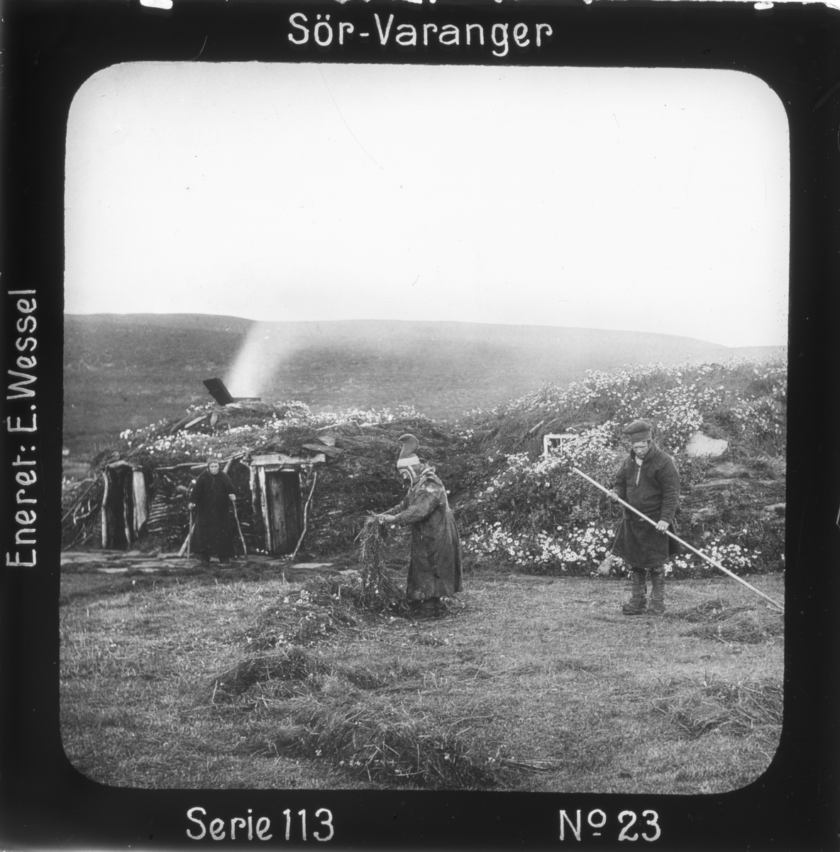 Ellisif Rannveig Wessel, Samisk torvgamme, Vestre Jakobselv, Vadsø, Finnmark. Maja Nilsens gamme, utenfor står søsknene Nils Maja, Anna og Gaisa Halt i døråpningen. 1897. Høyonn. Motivet har nr.23 i lysbildeforedraget kalt "I lappernes land - Sør-Varanger", utgitt i Nerliens Lysbilledserier, serie nr 113.