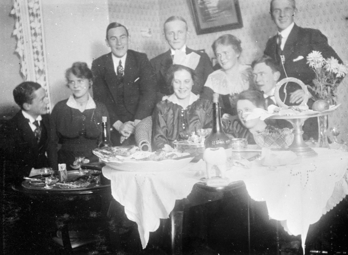 Anno Domkirkeodden, Interiør, hyble, selskap rundt bord, vin, kaker, frukt. Karl Løken.