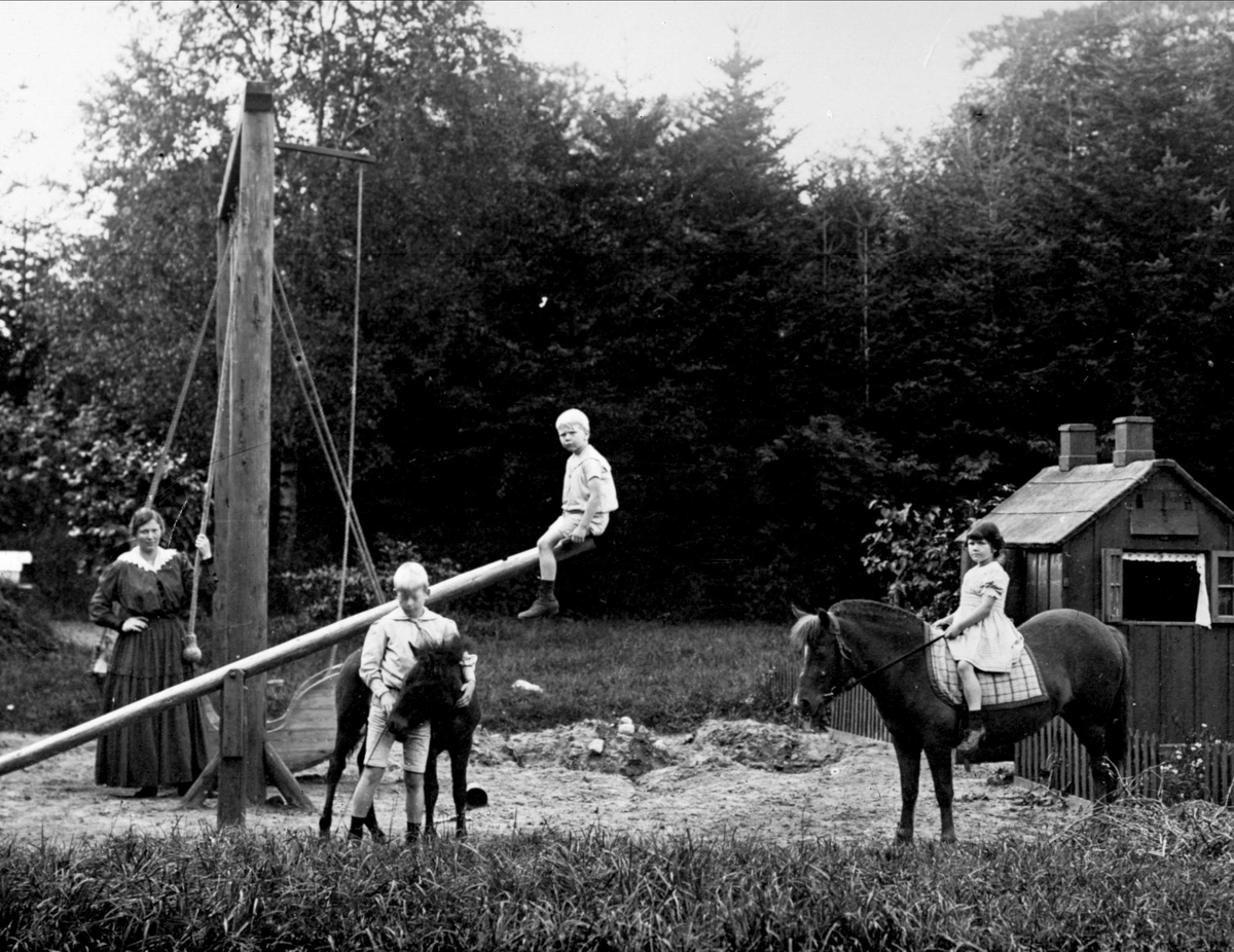 Gustav Borgen, Barn i lek utendørs, barnepike, et barn på vippe, to på hver sin hest.