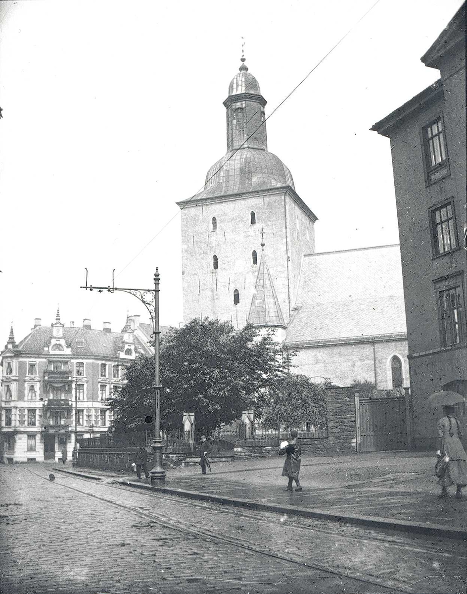 Tom Kent, Bybilde fra Bergen, kirken sentralt i bildet og trikkeskinner foran..