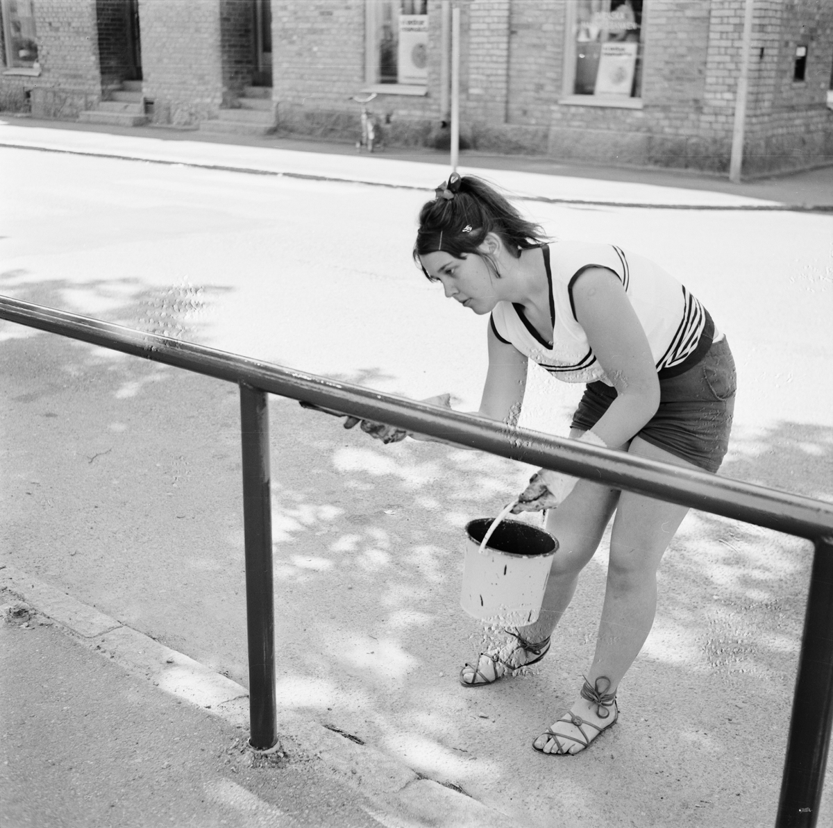 Tierp Arbetarbladet, Anneli Morberg målar staket under sitt feriearbete hos Tierps köpings parkavdelning, Tierp, Uppland juni 1968