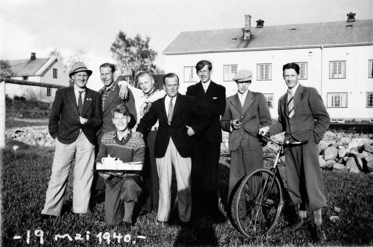 Anno Domkirkeodden, GRUPPE 8 UKJENTE MENN UTENFOR BØNDENES HUS I LØTEN. 19 MAI 1940. Nr 3 fra høyre - i mørk dress, er Ola Mikkelsen ( også kalt Ola Mikk)