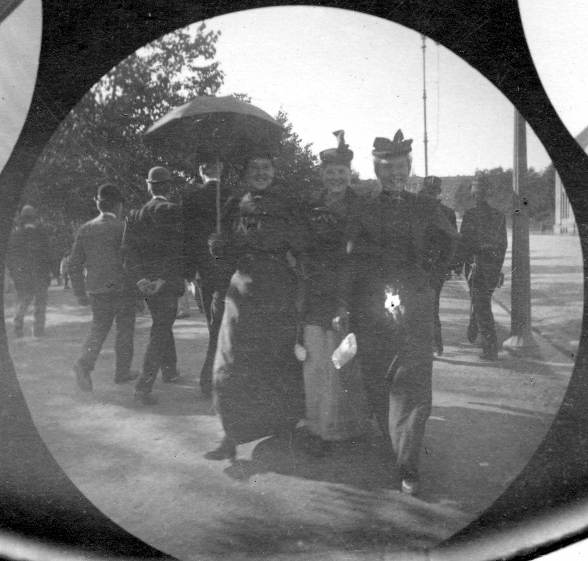 Fredrik Carl Mülertz Størmer, Mennesker spaserer langs Karl Johans gate, Oslo. Tre kvinner sammen midt i bildet.