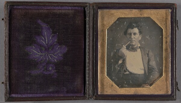 Unknown, [Portrait of a man smoking a small white clay pipe]