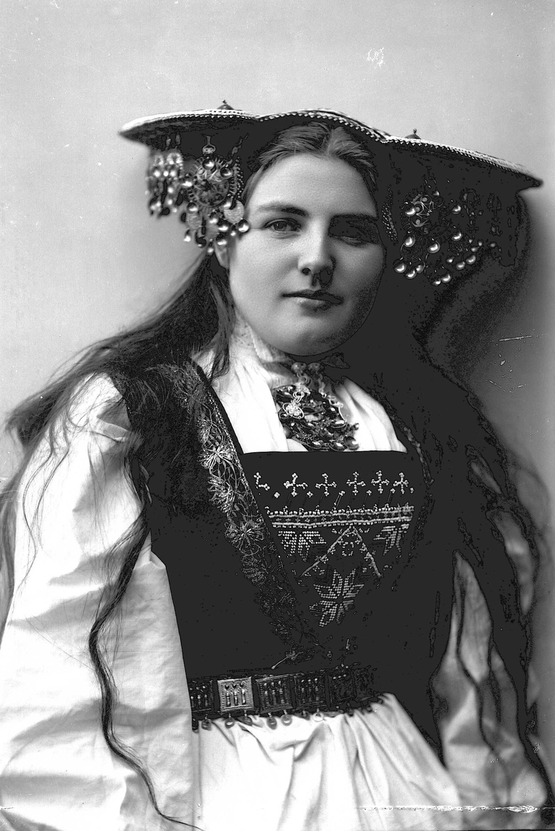 Solveig Lund, Studiofotografi av kvinne med brudedrakt og brudehatt på hodet. Hofteutsnitt. Frontalt vendt. Ser ut av bildet.