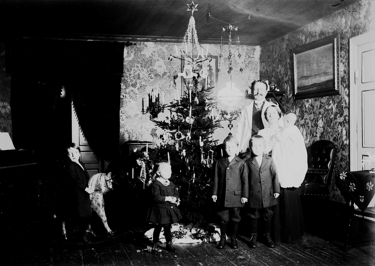 Axel Quinsgaard Wiborg, Familie feirer jul med juletre og gyngehest. Interiør, ant. fra Nedre Digerud, Frogn, Akershus, hos familien Quinsgaard Wiborg.
