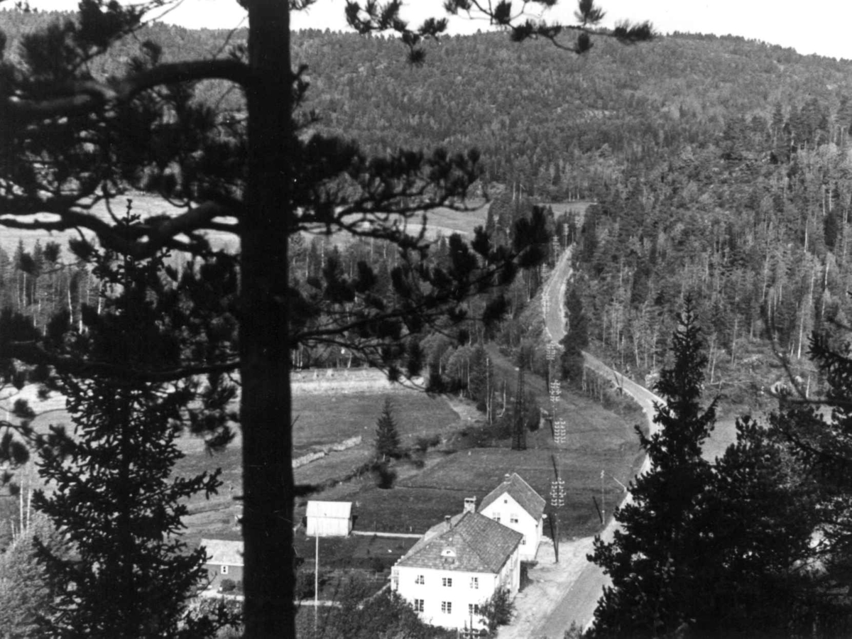 Anna Grostøl, Oversiktsbilde fra Fiane med bygninger ved en vei, 1938.