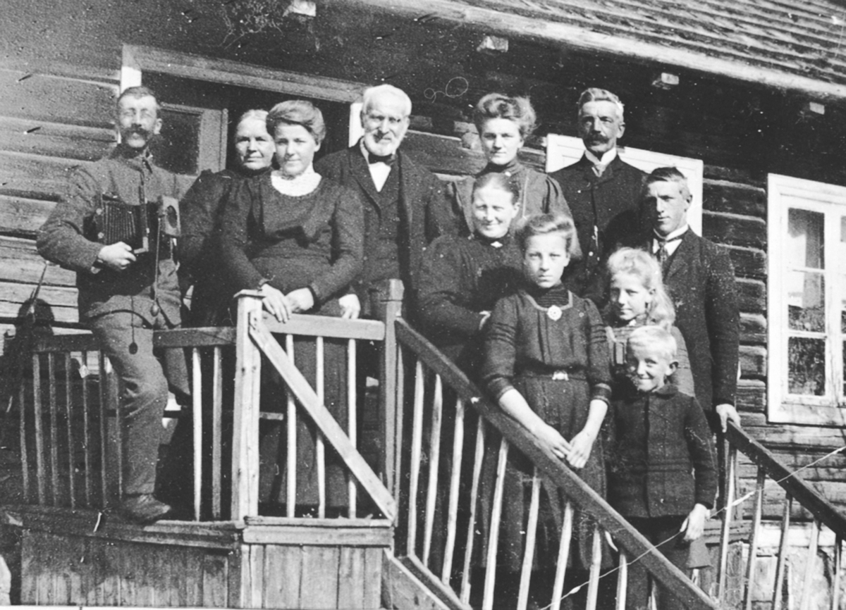 Anno Domkirkeodden, Elleve personer på trappa i Øvern, Stavsjø, Hedmark. Mann med fotoapparat.