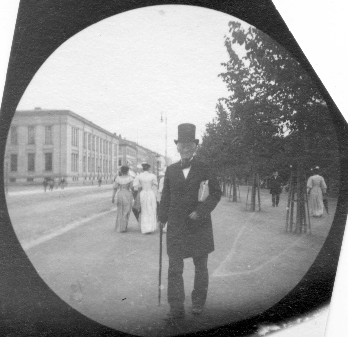 Fredrik Carl Mülertz Størmer, Redaktør Friele spaserer langs Karl Johans gate, Oslo, i Studenterlunden. Universitetet i bakgrunnen.