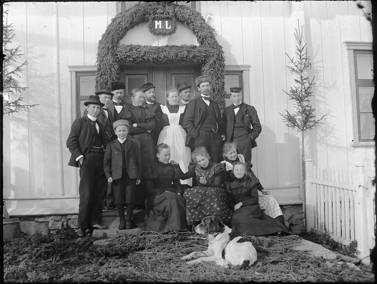 Ole Hansen Løken, BEGRAVELSE 1909. ETTER MARTHE LØKEN, GIFT M. HANS OLSEN ULVEN. FAMILIEGRUPPE FORAN INNGANG PYNTET MED GRANBAR OG INITIALENE M. L. FORAN F. V. HANS ULVEN, UKJENT, LALLY RING, ALBERTA SIGSTAD, OG TULLA HERSOUG. BAK. F. V. UKJENT, UKJENT, JACOB RING, MARTHE ULVEN, HANS ULVEN, MIMMI LØKEN, UKJENT, UKJE…