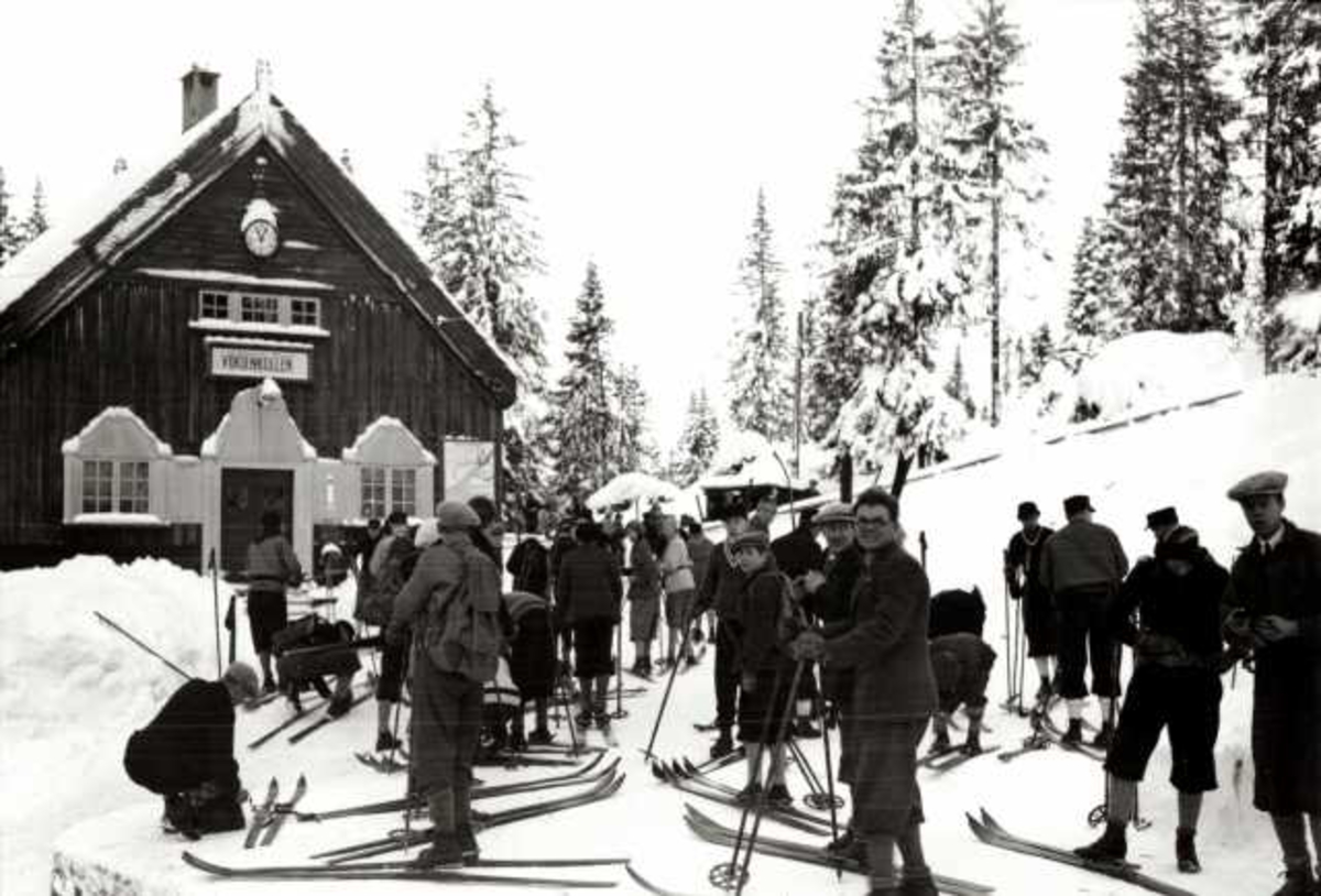 Hermann Christian Neupert, Voksenkollen stasjon, Nordmarka, Oslo. Vintermotiv. Skiløpere på stasjonen.