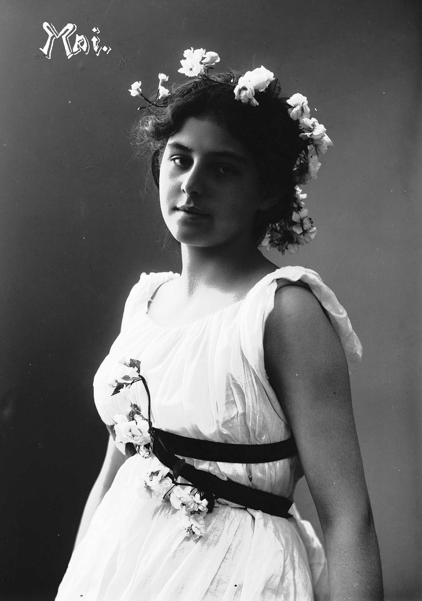 Solveig Lund, Studioportrett av kvinne i drakt med blomster i håret.