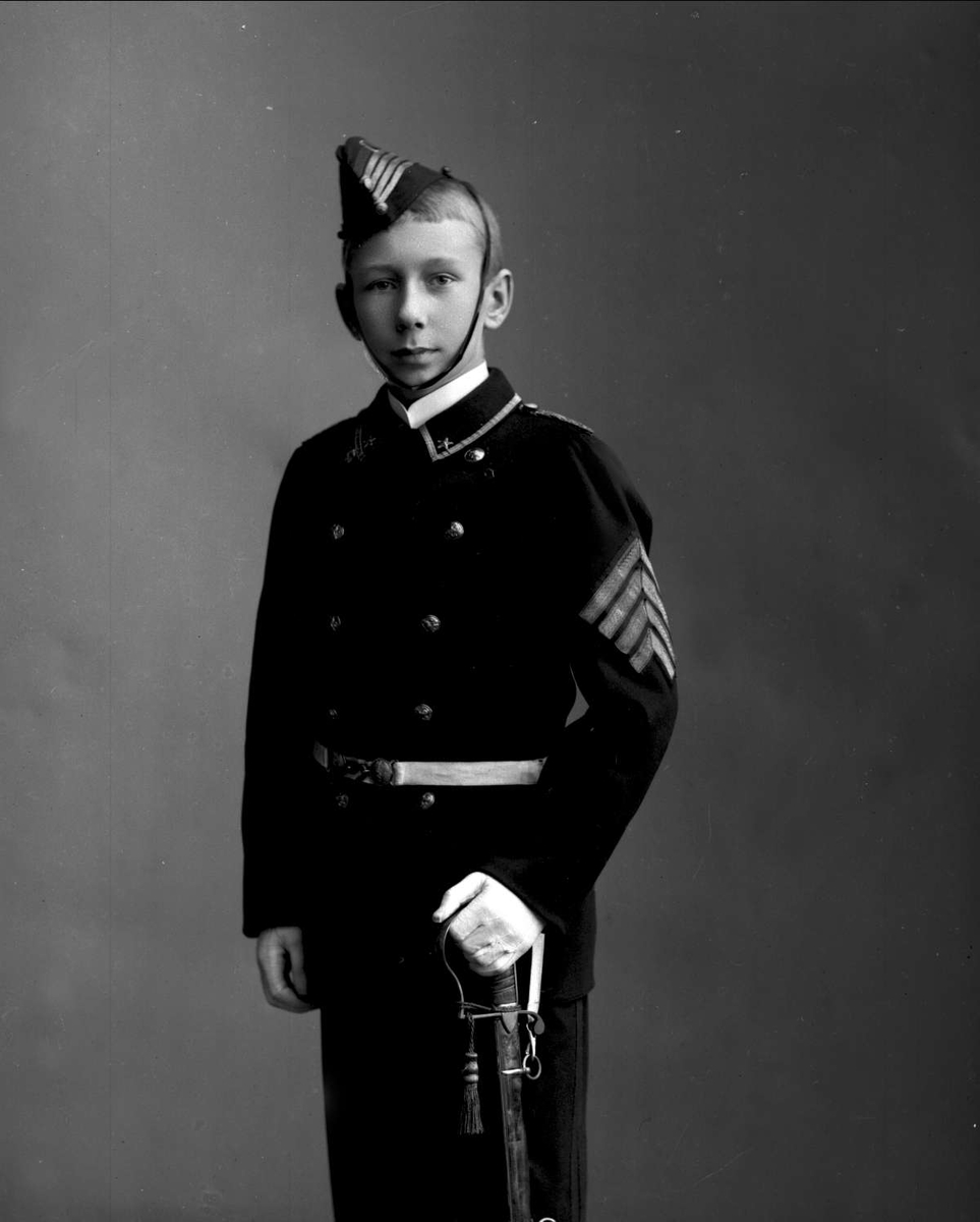 Gustav Borgen, Portrett, gutt i uniform. Buekorpsuniform, sannsynligvis Urania Garde. Uniformslue, med sidevåpen. Ivar Heide, f. 1888.