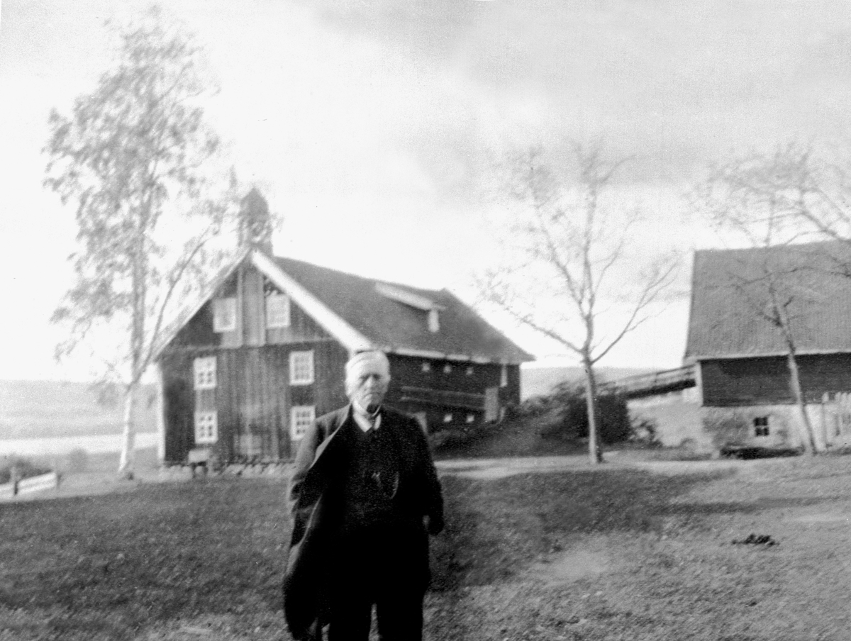 Anno Domkirkeodden, Even Arnt Nilsen Gjestvang (1829-1927) på tunet på Kise Mellem. I bakgrunn stabburet med matklokke som ble bygd i 1847.