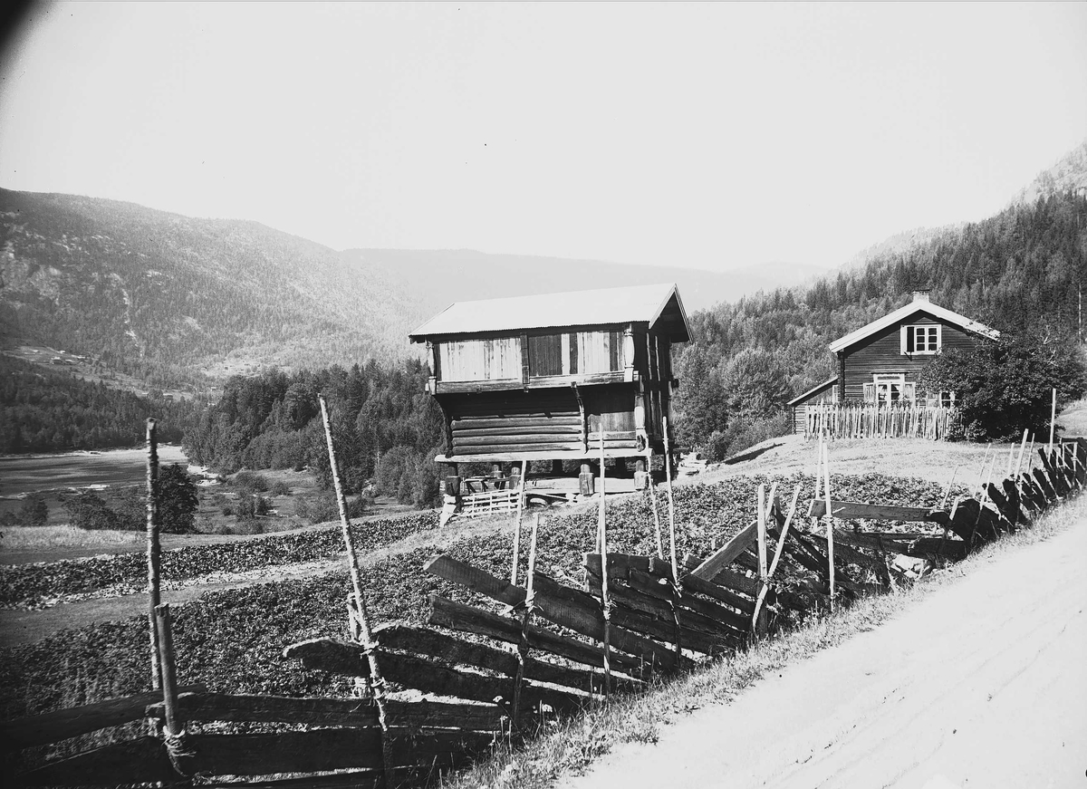 Axel Quinsgaard Wiborg, Kvisle, Numedal, Rollag, Buskerud, 1906. Tømmerhus og bur mot dal, med skigard fremst i bildet.