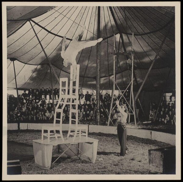 Hinde, John Wilfrid, man performing a one handed handstand on a stack of chairs