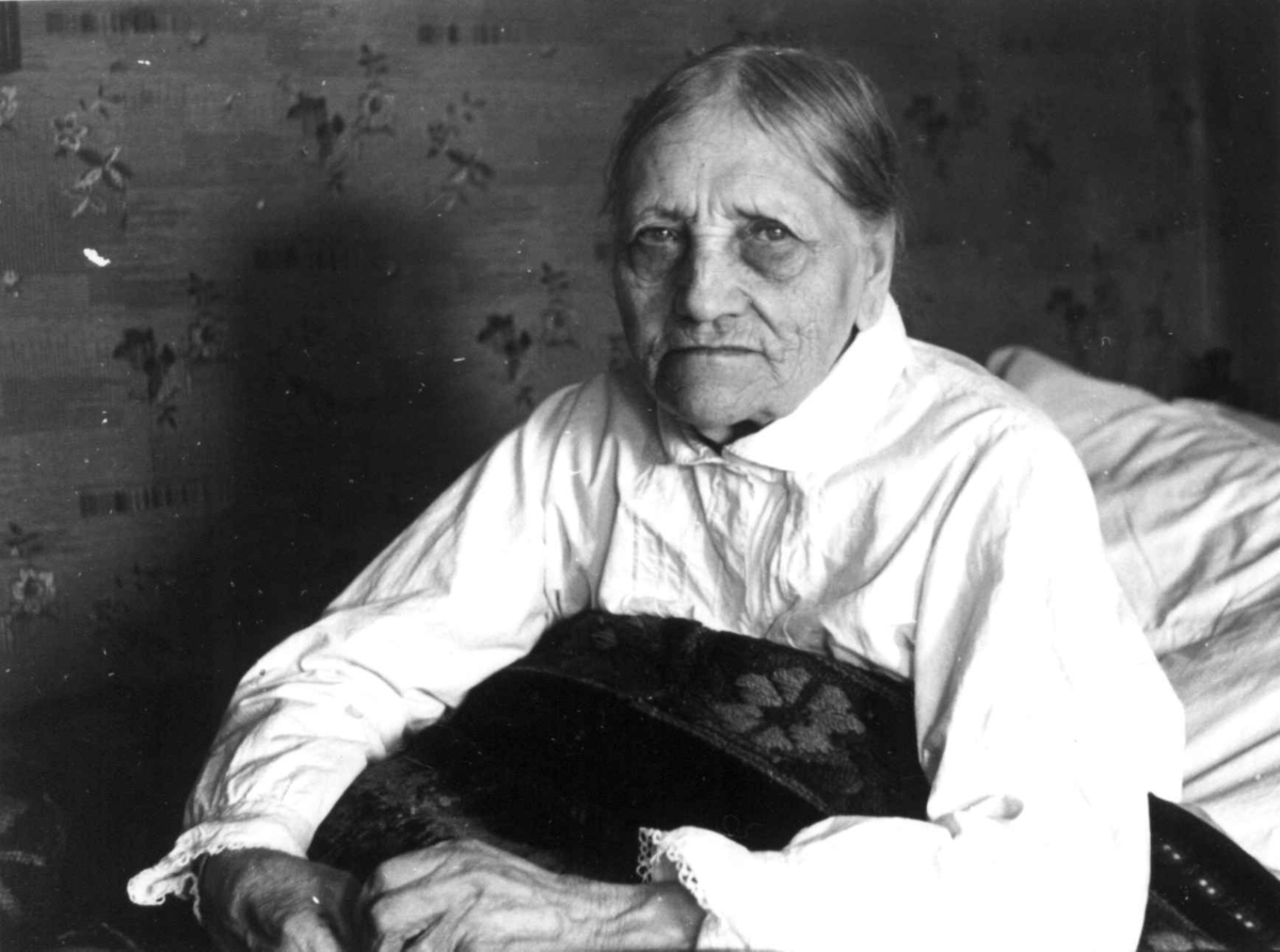 Anna Grostøl, Portrett av Åselina Eiken sittende i sengen. Eiken, Vest-Agder 1940.