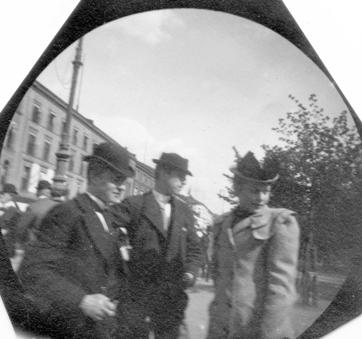 Fredrik Carl Mülertz Størmer, Frk. Andersen, senere fru l'Orange, og to menn står på fortau ved park, bygårder på den andre siden. Ant. Karl Johans gate, Oslo.