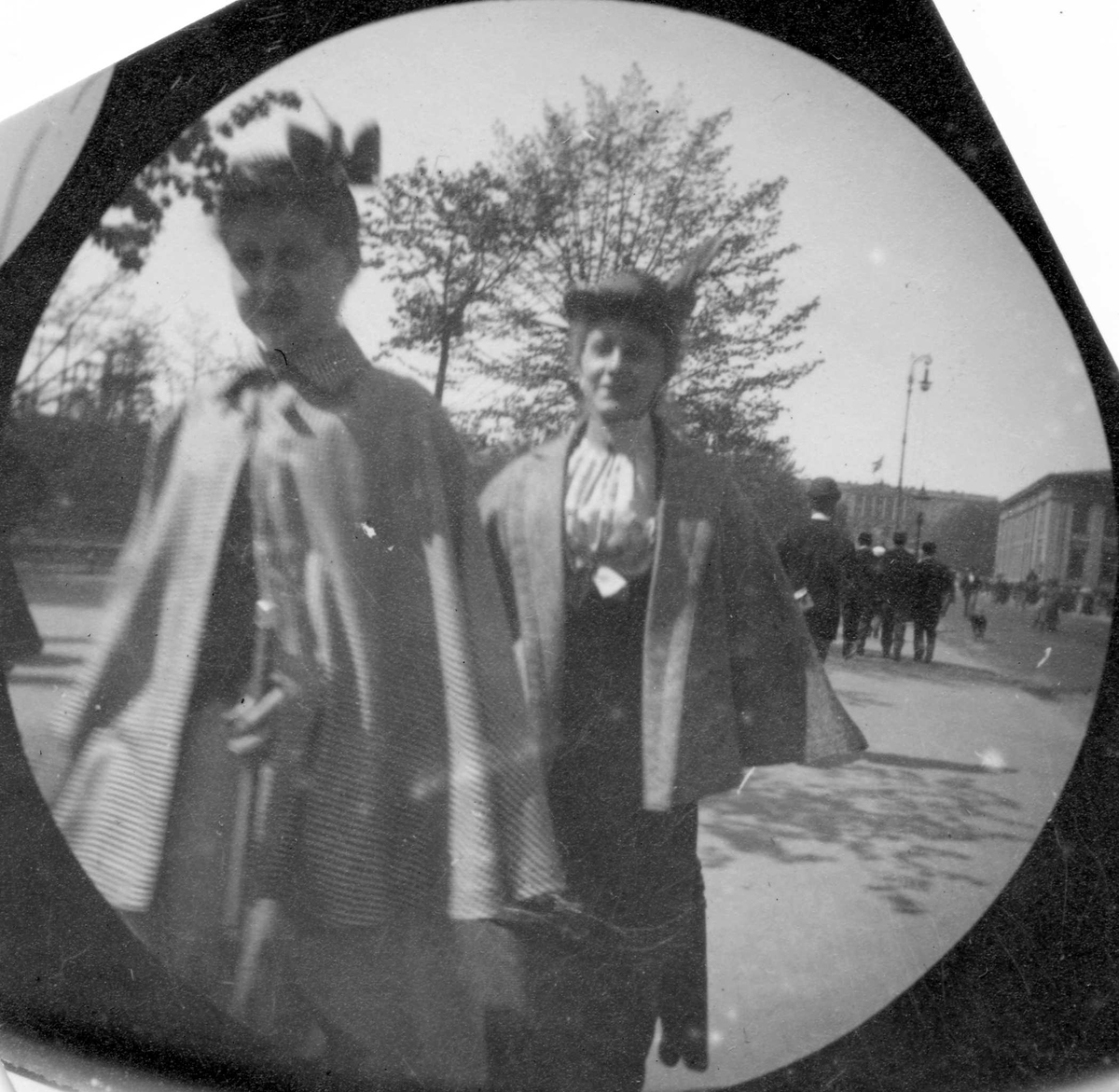 Fredrik Carl Mülertz Størmer, Frk.Smith til venstre og frk. Sørbøe spaserer langs Karl Johans gate, Oslo. Universitet og Slottet skimtes.